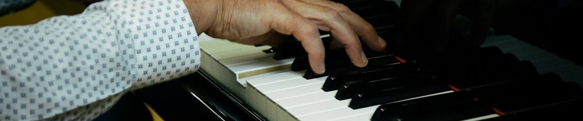 Handen op pianotoetsen