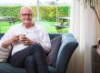 Stembevrijder Lambert op een bank bij piano