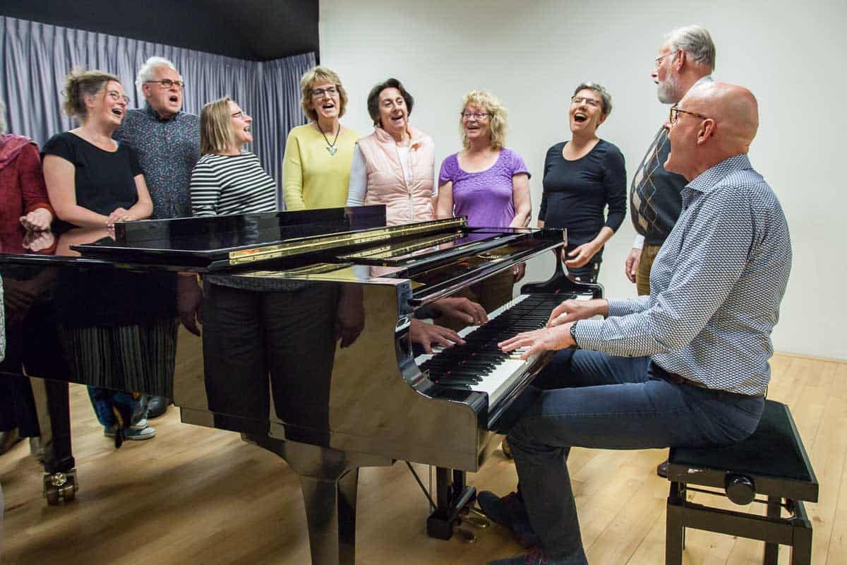 frionnet-20190510-8996-laag Groep mensen zingend bij de piano in workshop
